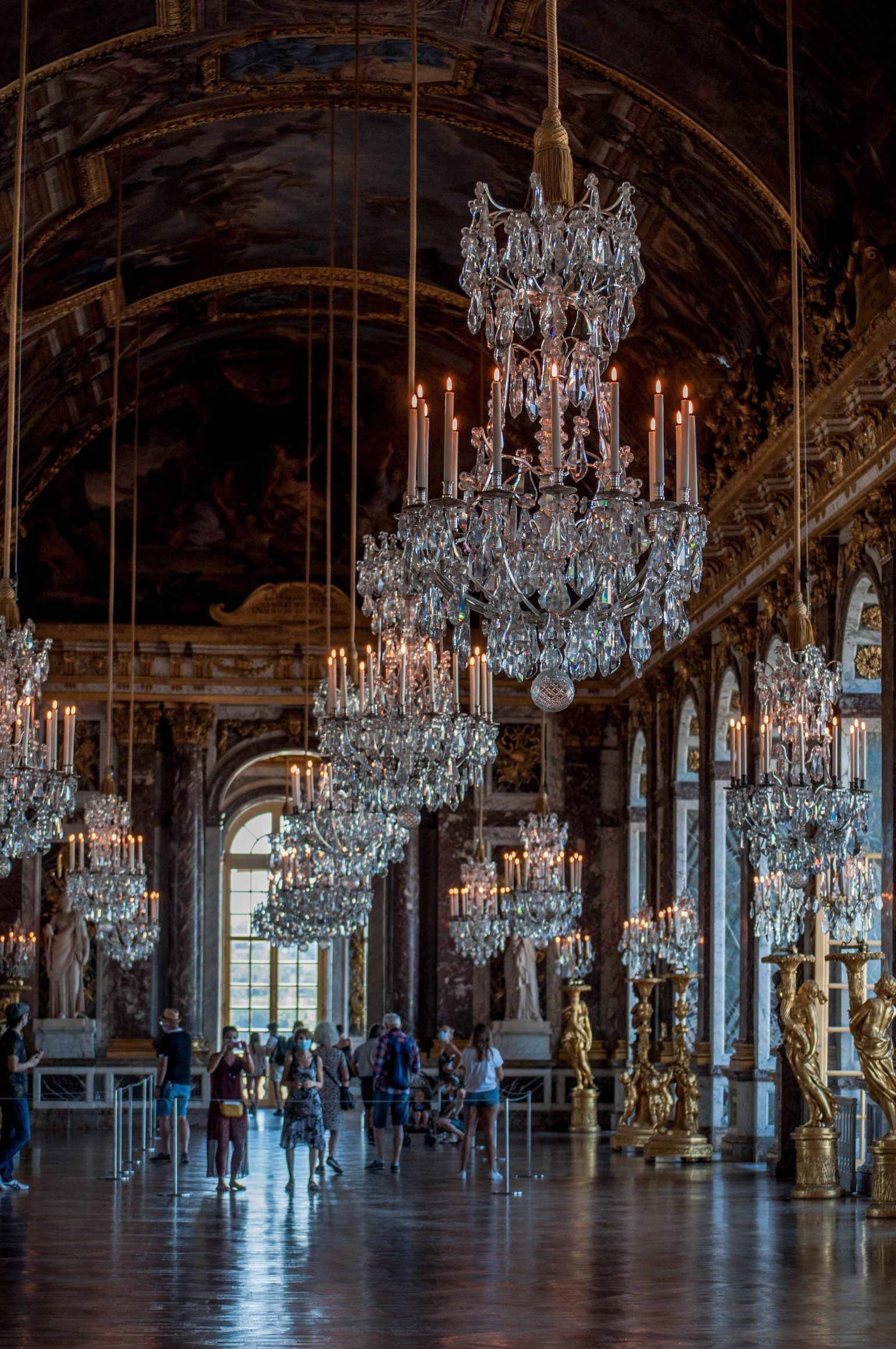 De grands lustres suspendus dans la galerie des glaces du château de Versailles, avec des barrières Q autoportantes absolues. De grands lustres suspendus dans la galerie des glaces du château de Versailles, avec des barrières Q autoportantes absolues.