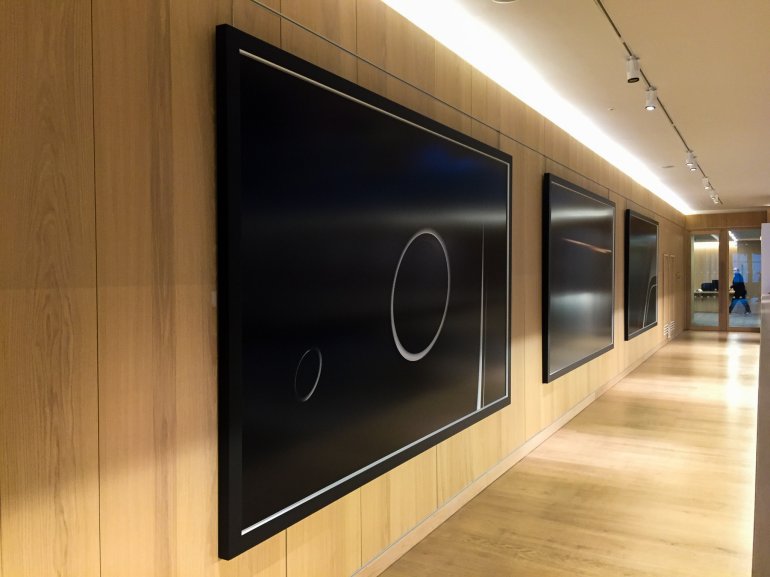 Grande œuvre d'art accrochée à un mur à l'aide de solutions de suspension d'œuvres d'art Absolute dans l'atrium du Design Museum de Londres.