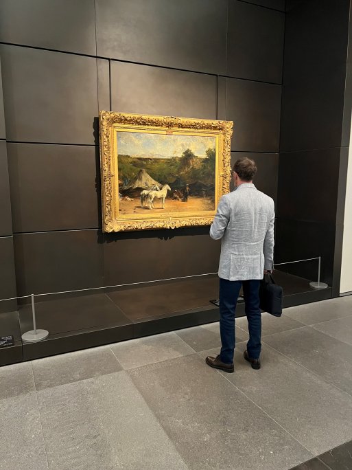 Une série de peintures exposées au Louvre Abu Dhabi, protégées par des barrières de musée.