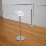 Une galerie d'art utilisant des barrières Q indépendantes avec plaque de signalisation et cordon de barrière, restreignant l'
