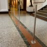 Quatre barrières Q montées sur la surface en acier inoxydable aligné horizontalement face au fond d'un escalier dans un musée